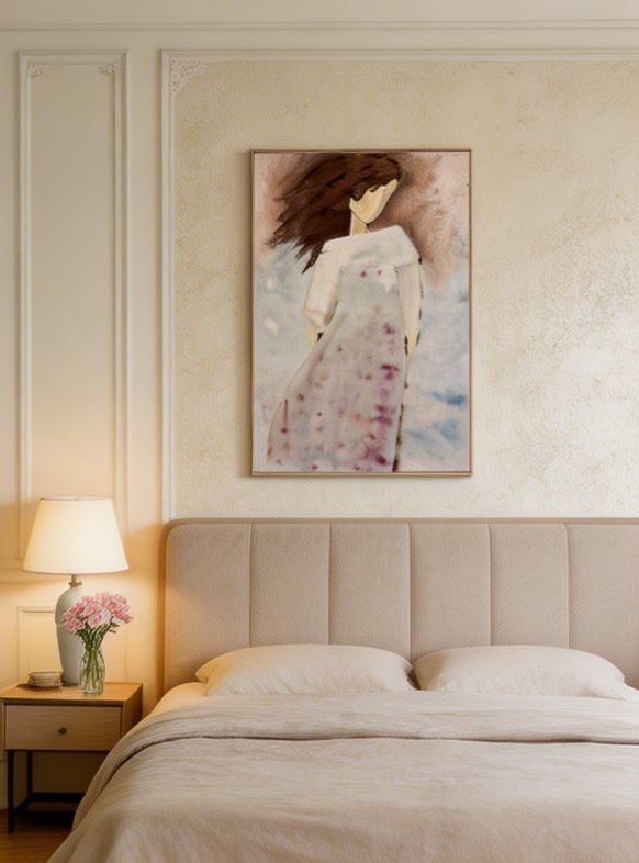 Modern bedroom with beige upholstered headboard, white bedding, artwork of woman in floral dress above bed, and nightstand with lamp and flowers